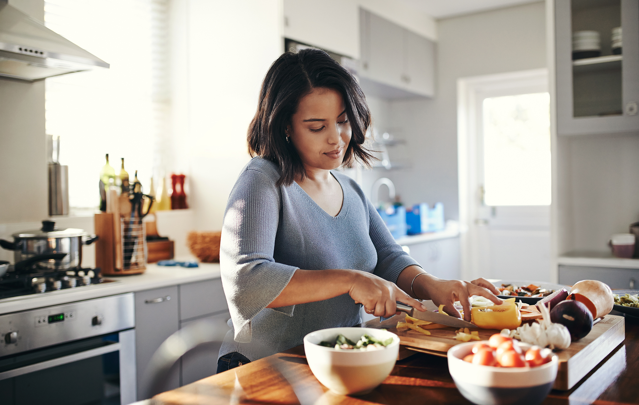 Shot of a young woman cooking at home