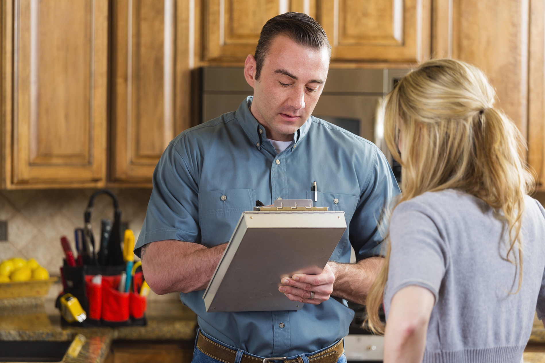A contractor helping a homeowner in the kitchen