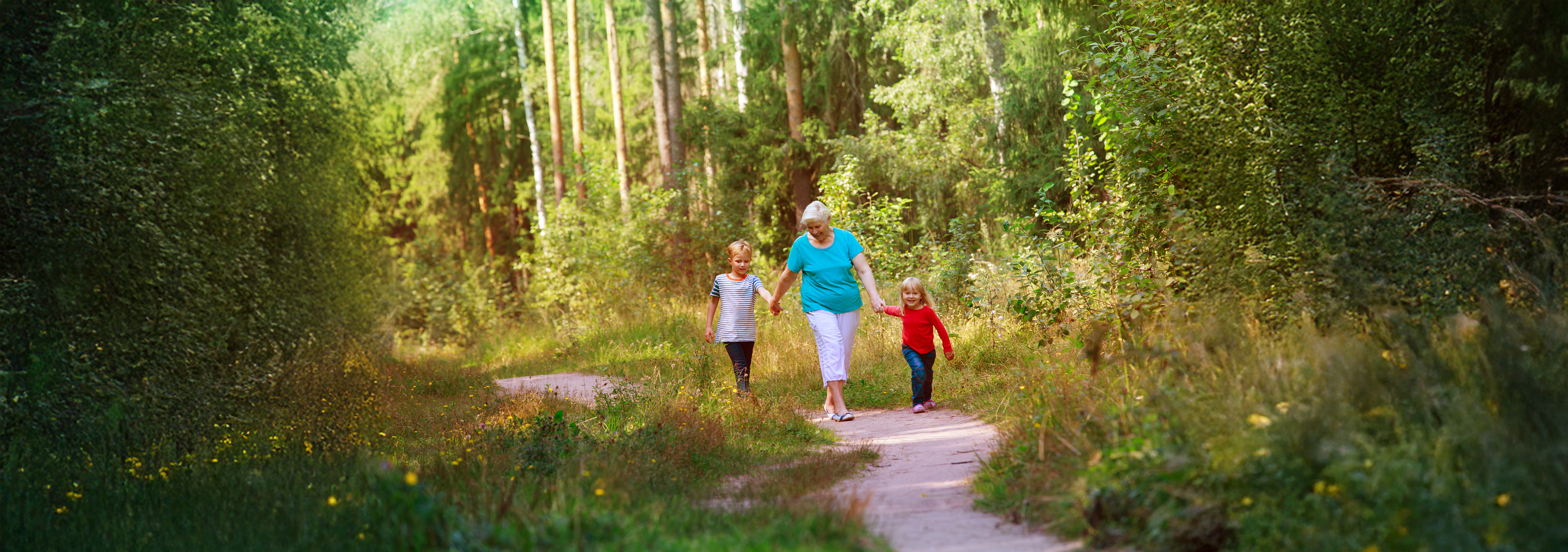 Happy grandmother with her grandkids, walking in nature